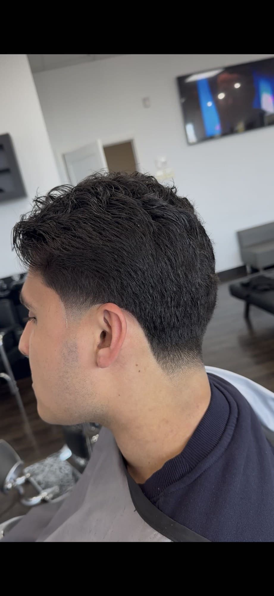 Low taper on wavy hair, in the chair