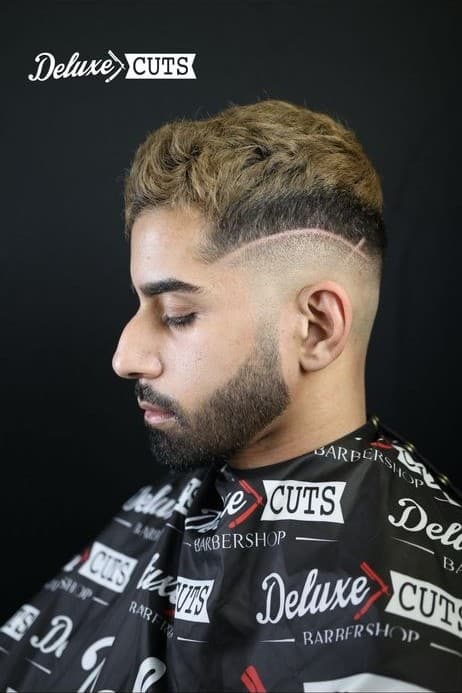 Blonde-tipped textured crop with a hard part and skin fade
