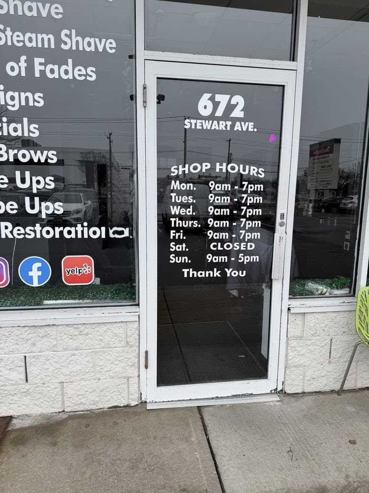 The front door with shop hours painted on the glass